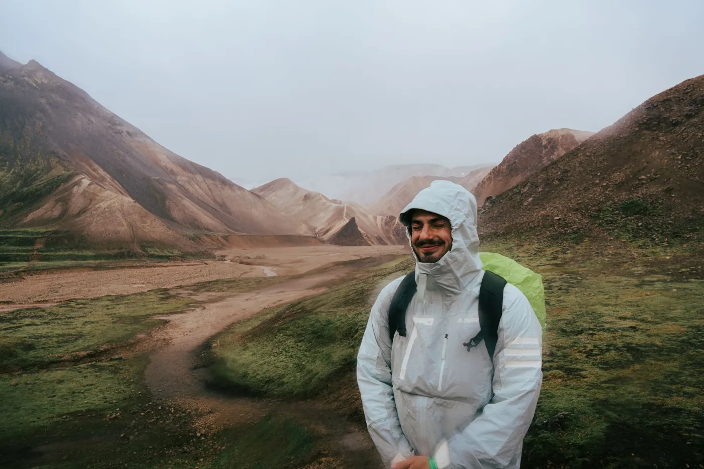 Wanderer in Regenjacke und mit Rucksack im isländischen Hochland