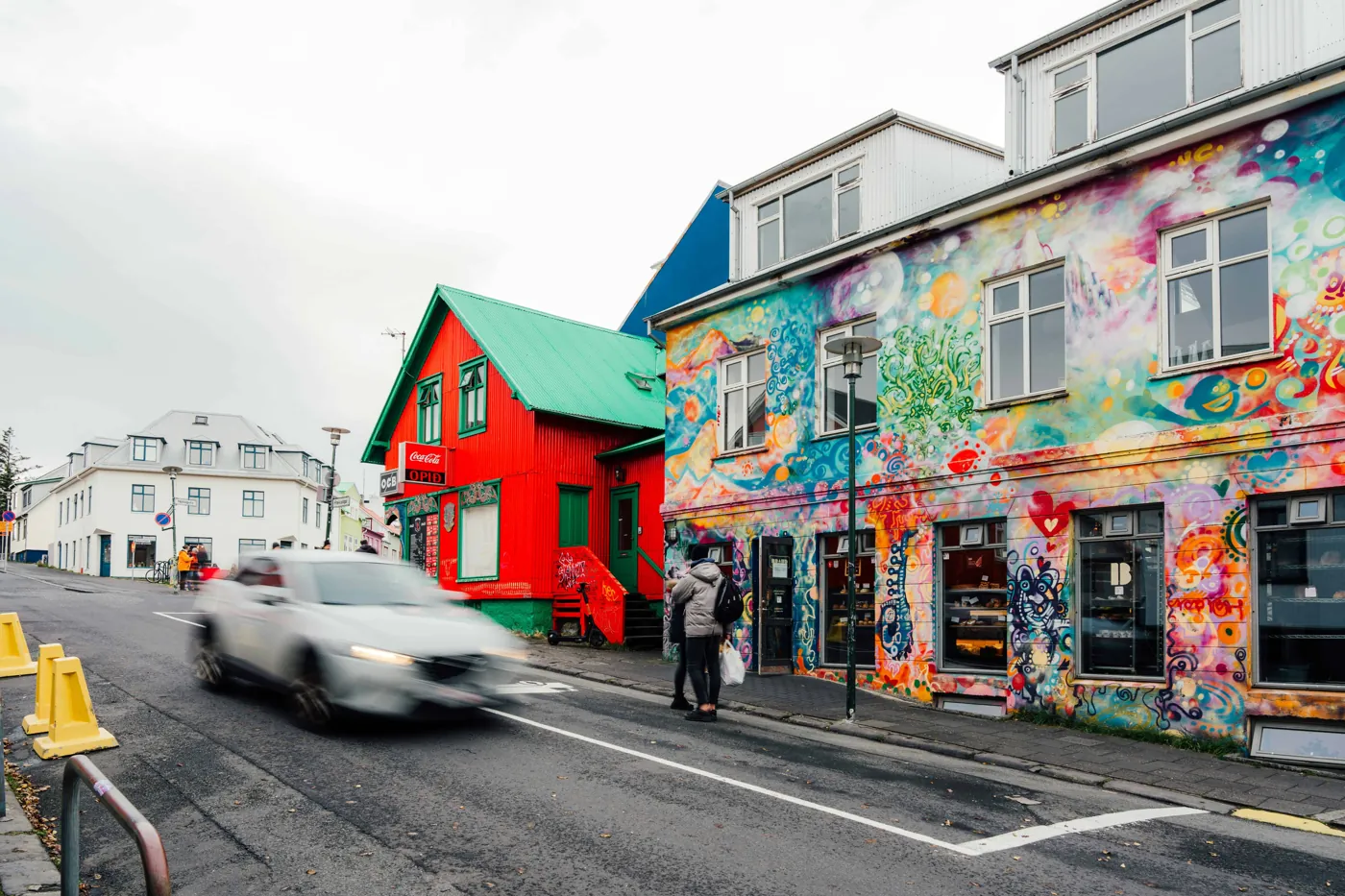 Bunt bemalte Hausfassade und rotes Holzhaus in der Innenstadt von Reykjavík