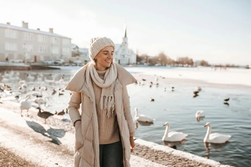 Frau am Stadtsee Tjörnin in Reykjavík im Winter