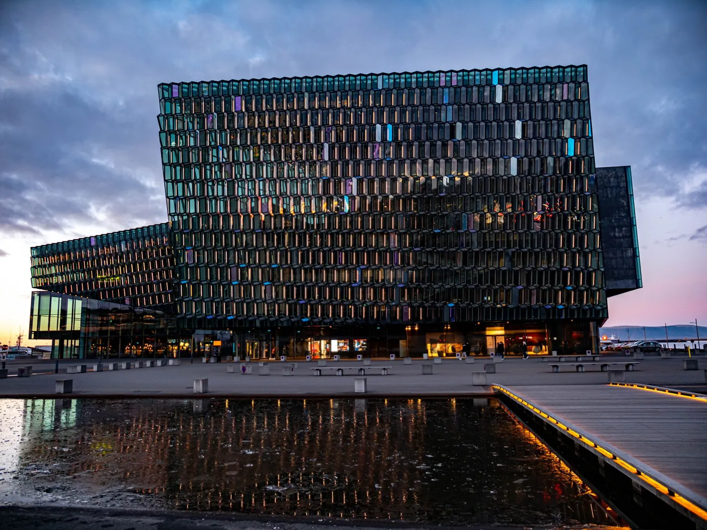 Das beleuchtete Konzerthaus Harpa in Reykjavík in der Abenddämmerung
