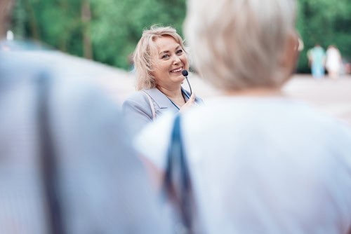 Weiblicher Tourguide mit einem Mikro